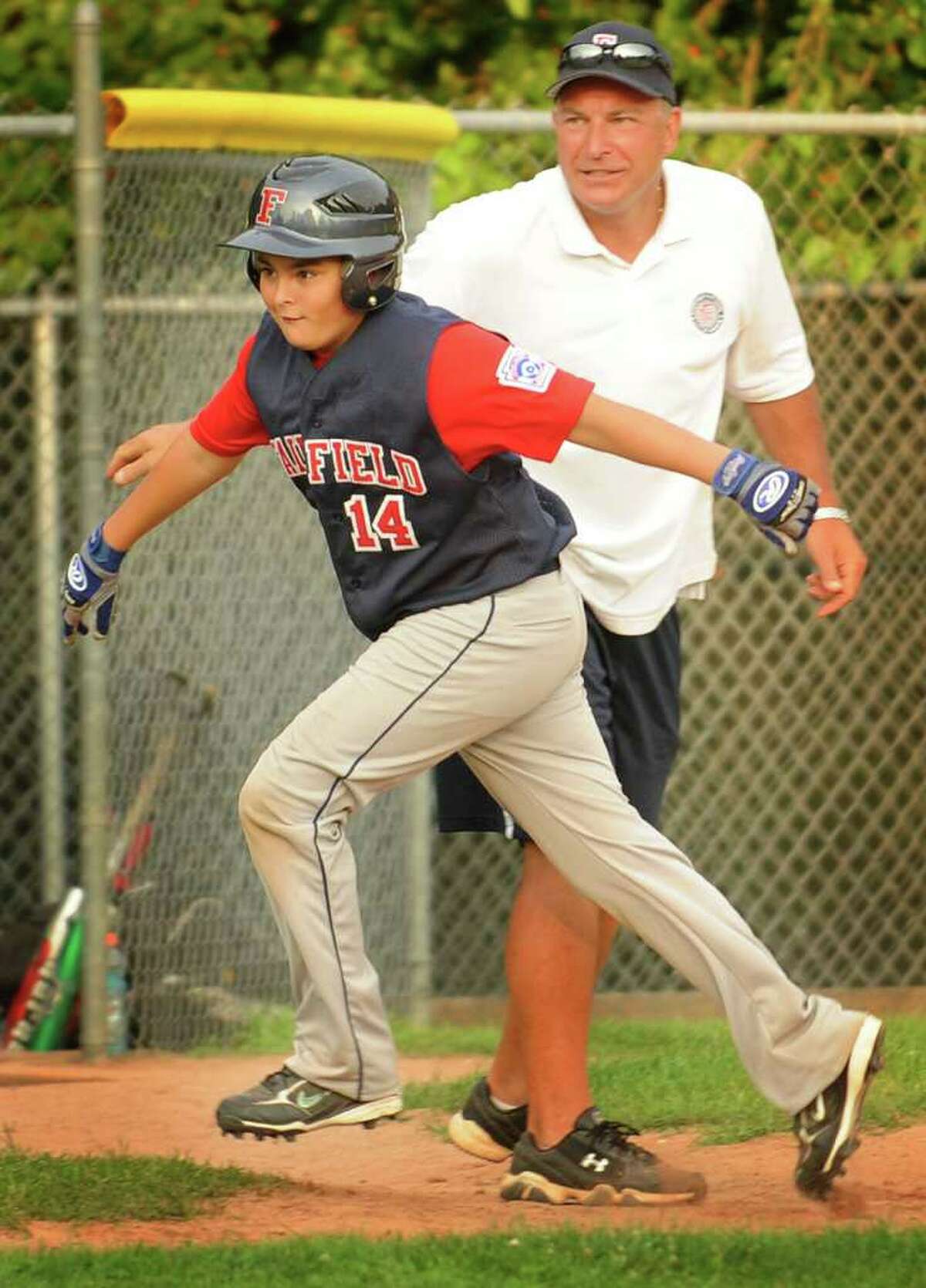 Fairfield National's Zavier Espina rounds third base after hitting a three run home run in the sixth inning of their Little League matchup with Trumbull American at Blackham School in Bridgeport on Monday, July 11, 2011. Fairfield National won the game 4-3.