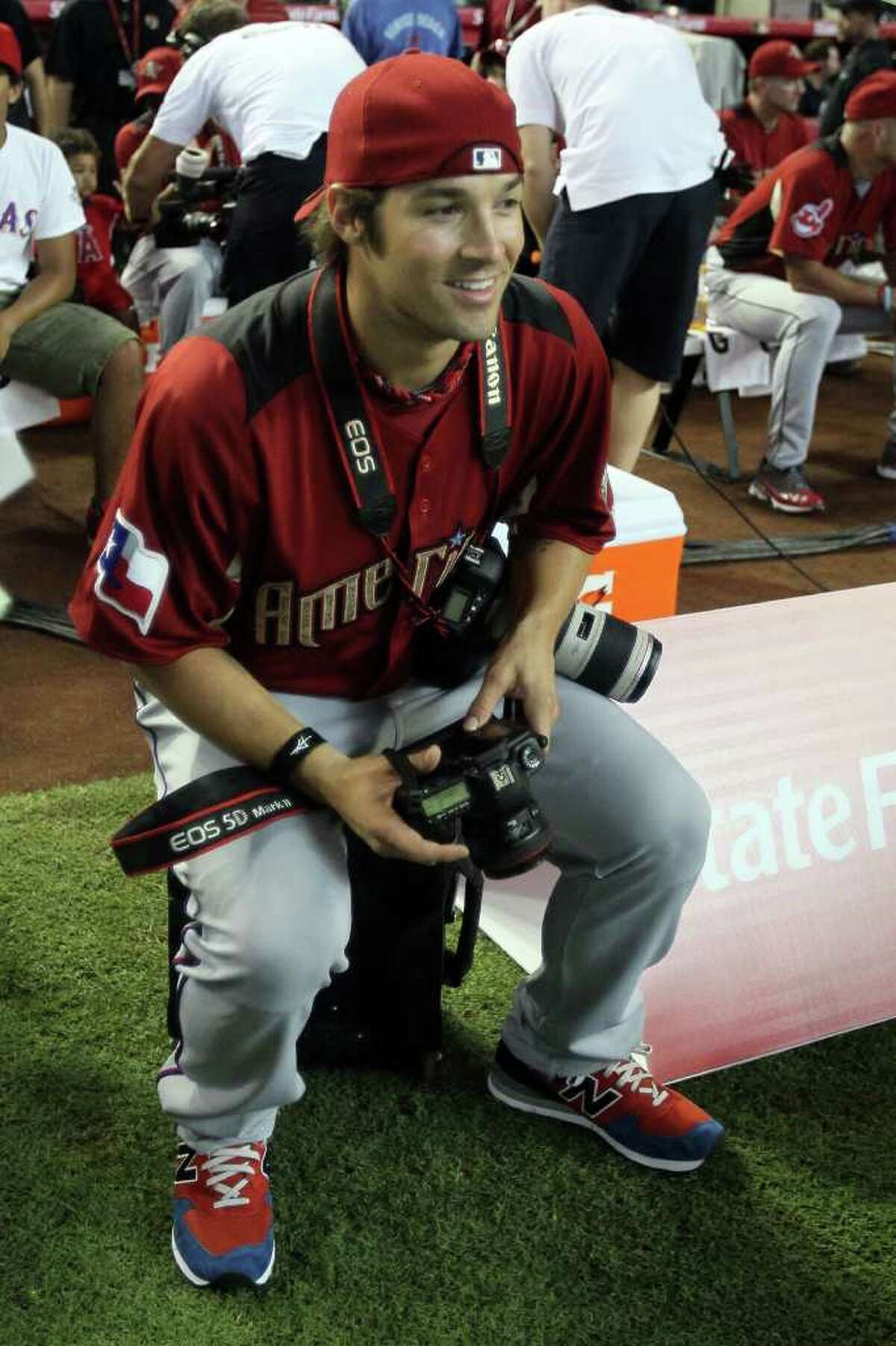 PHOENIX, AZ - JULY 11: American League All-Star C.J. Wilson #36 of the Texas Rangers looks on with his cameras during the 2011 State Farm Home Run Derby at Chase Field on July 11, 2011 in Phoenix, Arizona. (Photo by Jeff Gross/Getty Images)