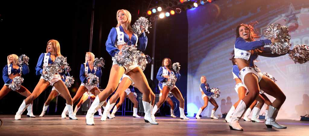 A fan wears a Dallas Cowboy cheerleader costume and pink gloves in