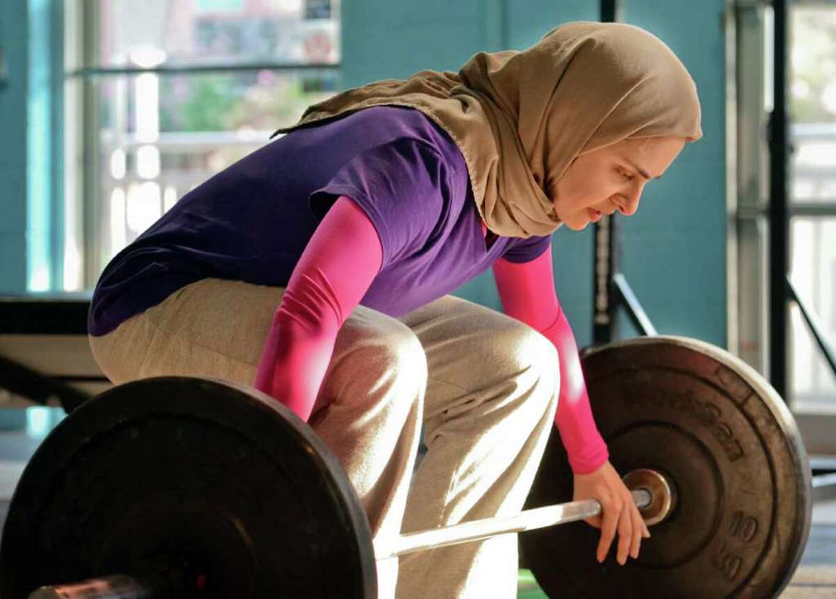 In this photo made Monday, July 11, 2011, Kulsoom Abdullah trains at Crossfit gym in Atlanta, Ga. Abdullah?’s Ph.D. from Georgia Tech and black belt in taekwondo are proof she doesn?’t back away from challenges. Abdullah on Friday will become the first woman to compete in the national weightlifting championships while wearing clothing that covers her legs, arms and head, in keeping with her Muslim faith. (AP Photo/Joey Ivansco)