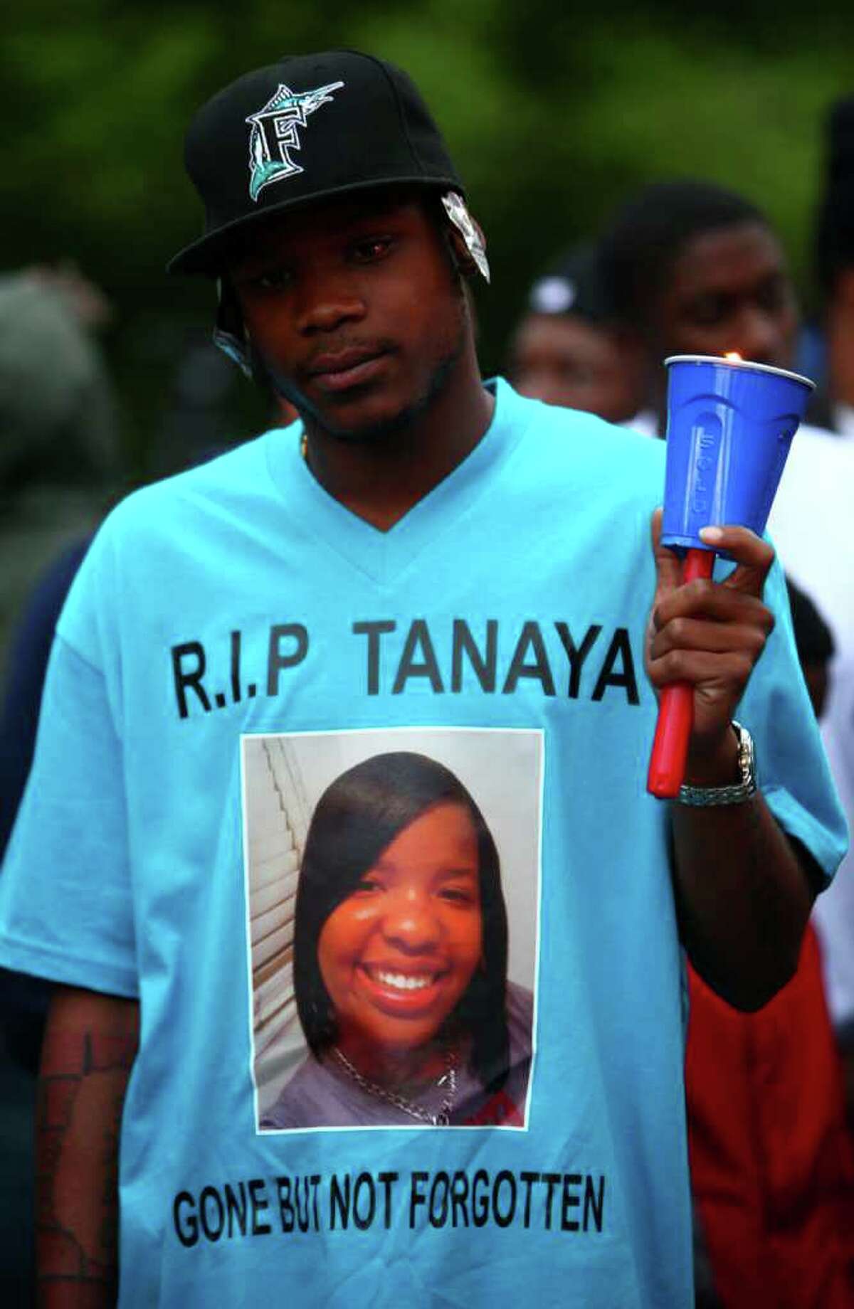 Aufu Snow wears a shirt memorializing Tanaya Gilbert, a 19 year-old woman shot and killed in South Seattle. A vigil was held for the woman, who was pregnant, on Thursday, July 14, 2011 on 54th Avenue South, site of the shooting. More shots were fired as the vigil was winding down. Police said someone fired on a blue and silver Dodge Magnum with chrome wheels. The car sped off after the shooting.