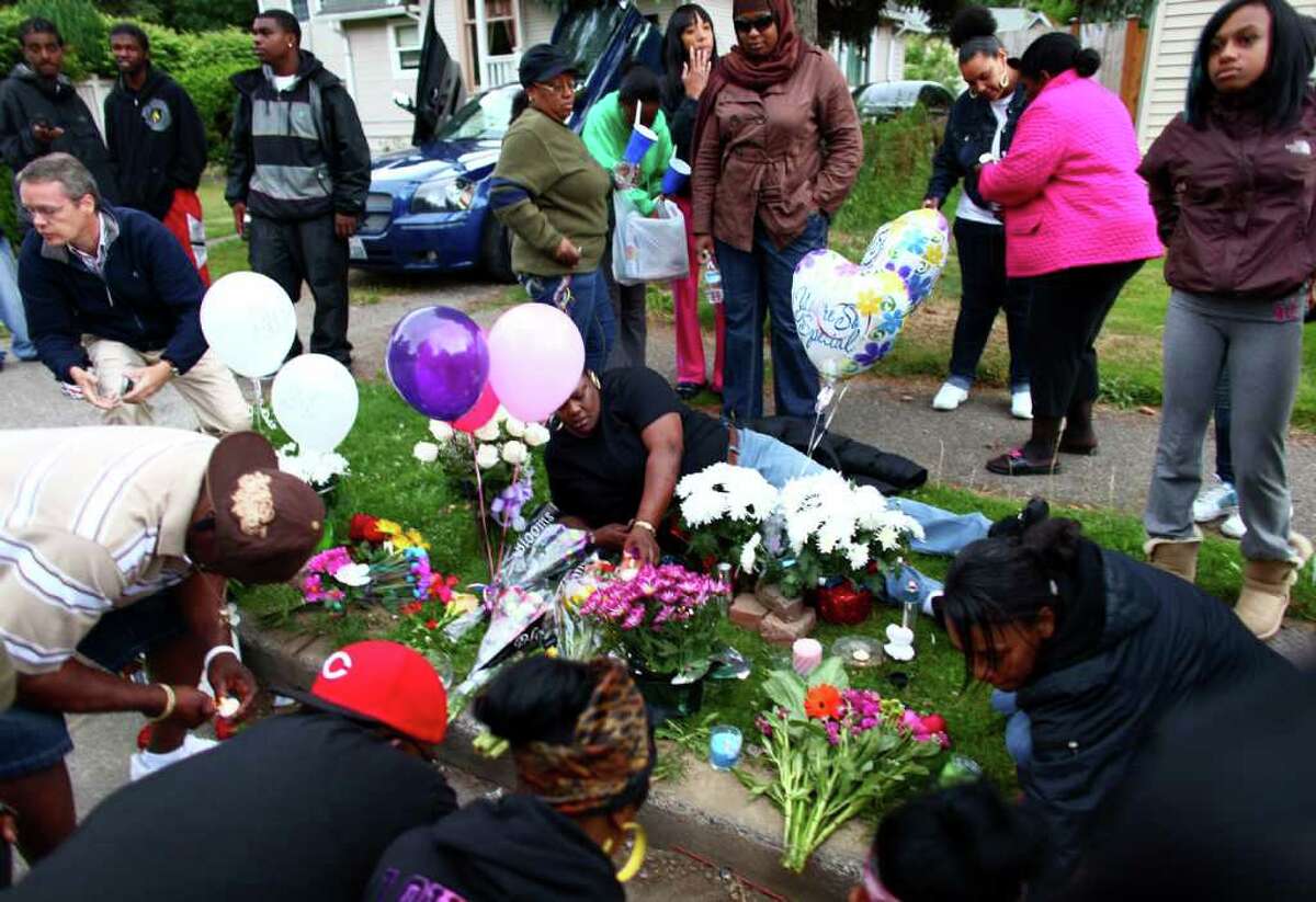 Mourners arrange candles and flowers during a memorial for Tanaya Gilbert, a 19 year-old woman shot and killed in South Seattle. A memorial was held for the woman, who was pregnant.