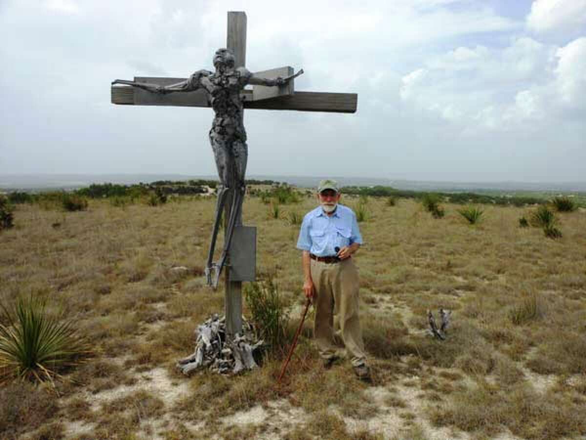 Artist Phil Evett stands beside his 1962 work "Crucifix" atop a plateau at his Blanco home. Photos by Steve Bennett/sbennett@express-news.net