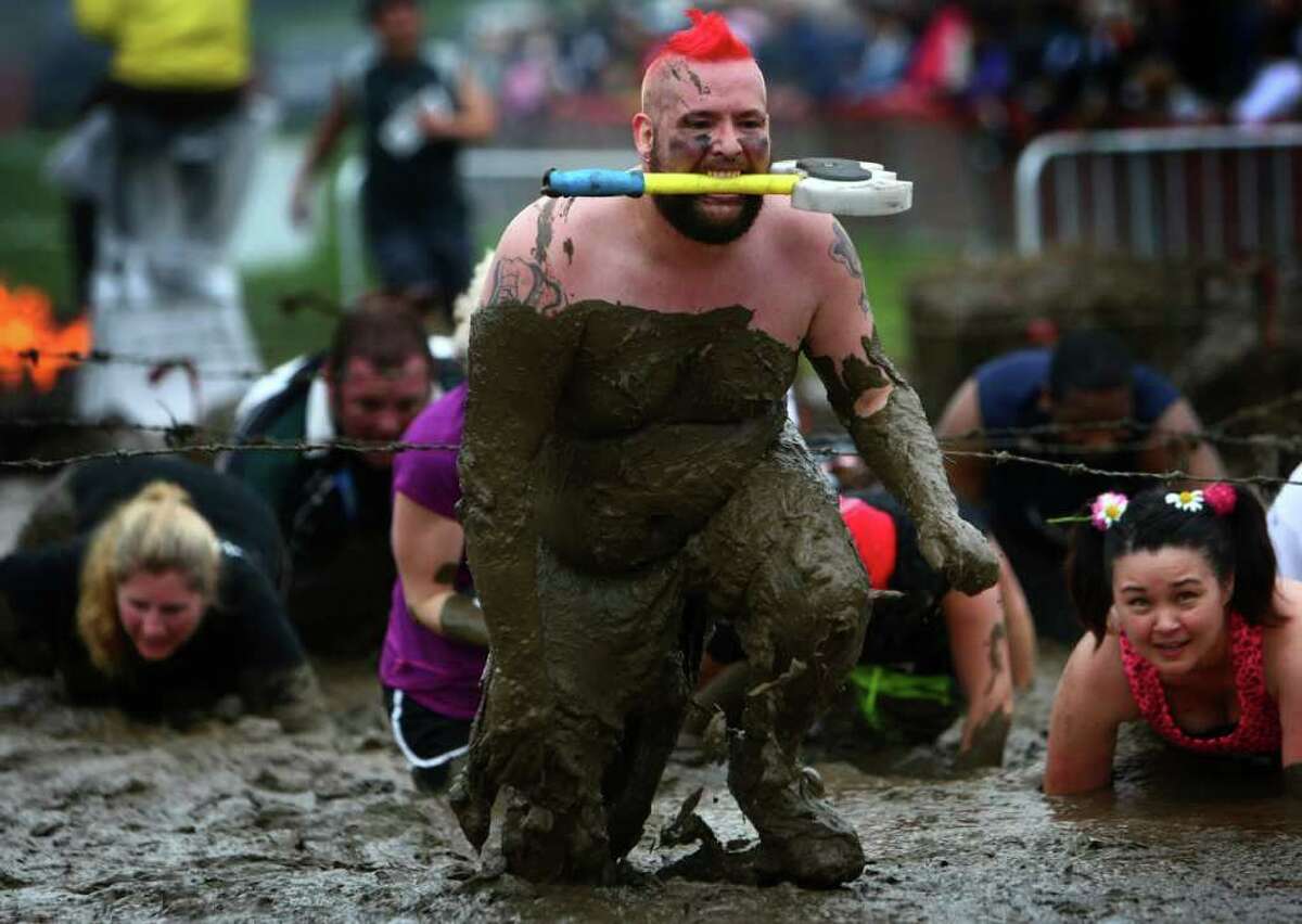 A participant slogs through mud during the inaugural Warrior Dash Washington in North Bend. Approximately 23,000 people competed in the 3.55 mile course which included a mud pit and flaming obstacles.