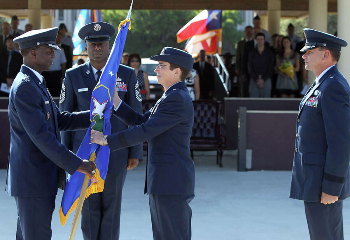 Air Force Brigadier General Theresa C. Carter (center) accepts command of the 502d Air Base Wing Joint Base San Antonio on July 18, 2011 during a change of command ceremony at the MacArthur Parade Field at Fort Sam Houston. Handing over the flag (left) is the event's presiding officer General Edward A. Rice, Jr. and standing on the right is Brigadier General Leonard A. Patrick who is stepping down as commander of Joint Base San Antonio. Standing between Rice and Carter (facing) is Command Chief Juan Lewis.