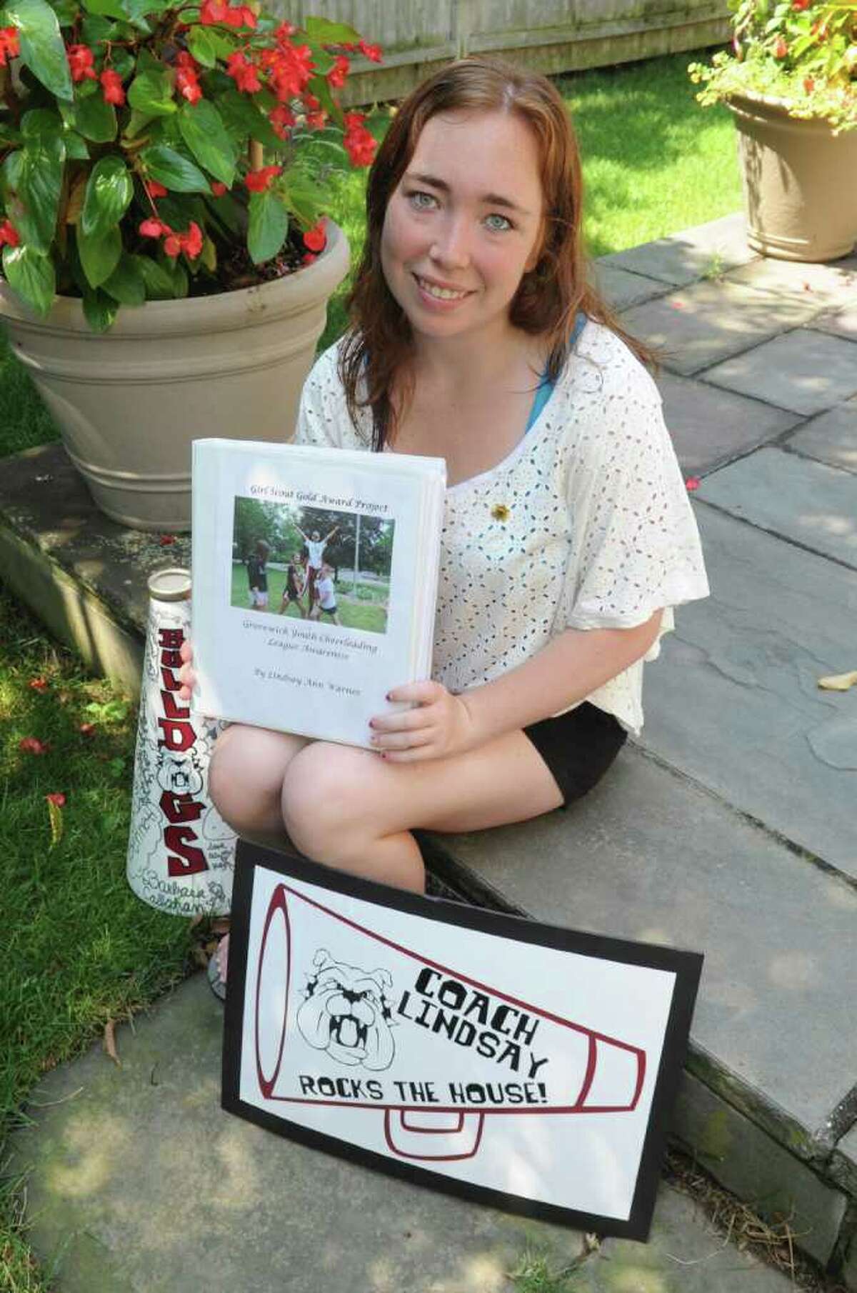 Lindsay Warner, 18, recently earned her Girl Scout Gold Award for her work with young Mianus Bulldogs cheerleaders. She sits with Girl Scout Award Project file on Tuesday, July 19, 2011.