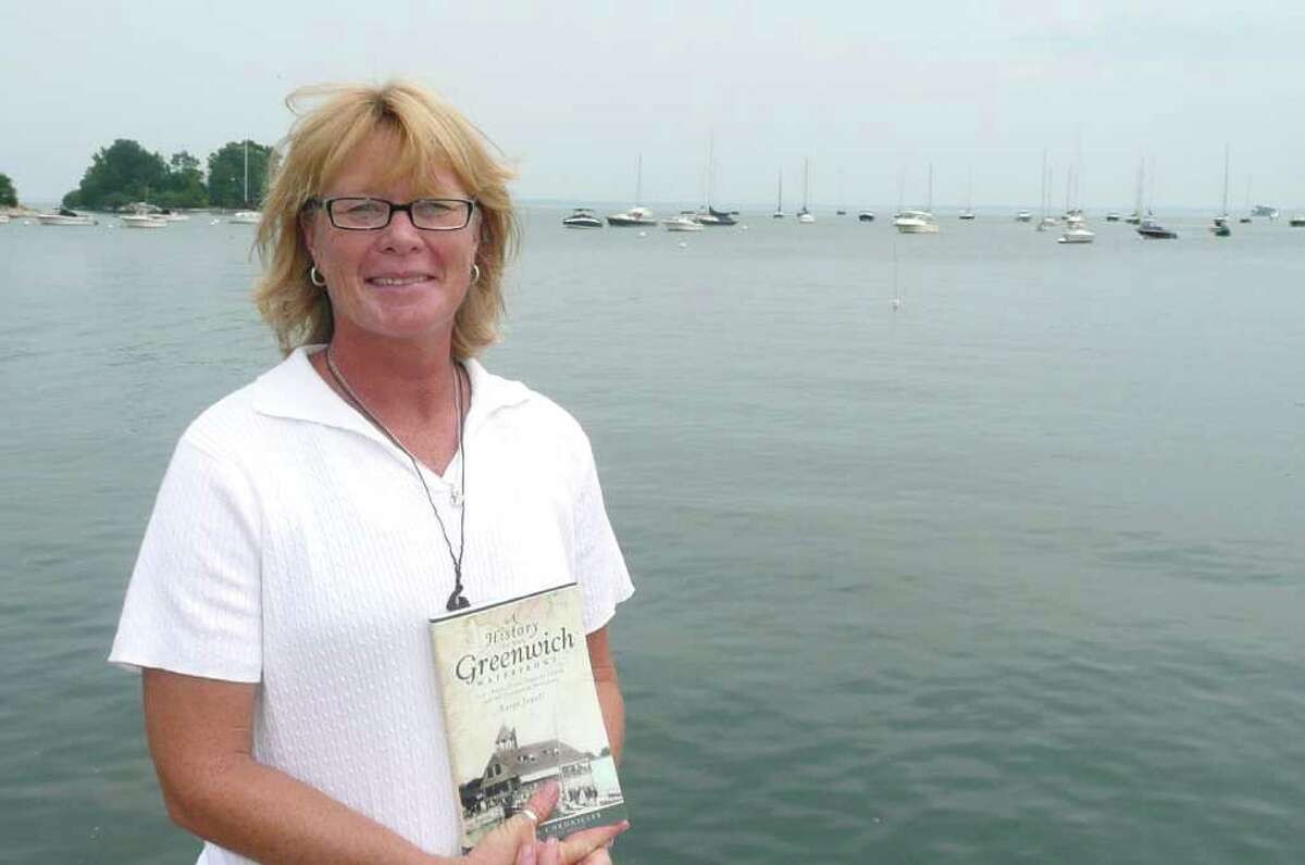 Author Karen Jewell holds her new book, "A History of the Greenwich Waterfront: Tod's Point, Great Captain Island and the Greenwich Shoreline," while standing at the end of Steamboat Road. The road was often called "Catfish Row" during the 1920s, Jewell writes in her book.