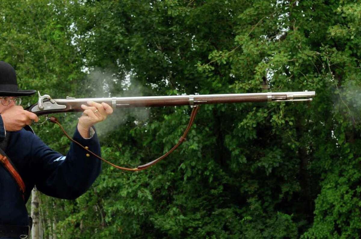 Civil War re-enactor Howard Young, a Rotterdam resident and member of the 125th New York Volunteer Infantry re-enactors group, fires his musket during a contrast and comparison between today's military uniform and that of the Civil War at the NYS Division of Military Affairsin Latham NY Wednesday July 20,2011.( Michael P. Farrell/Times Union)