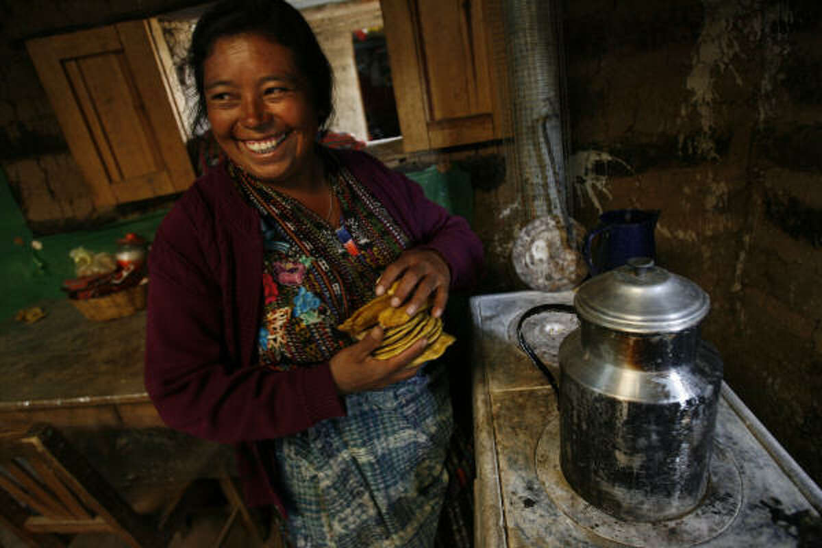 Sebastiana Vicente, de 40 años, con las tortillas que cocinó con su nueva estufa a leña Onil, que le entregó la organización Helps International en San Jorge la Laguna, en las montañas de Guatemala.
