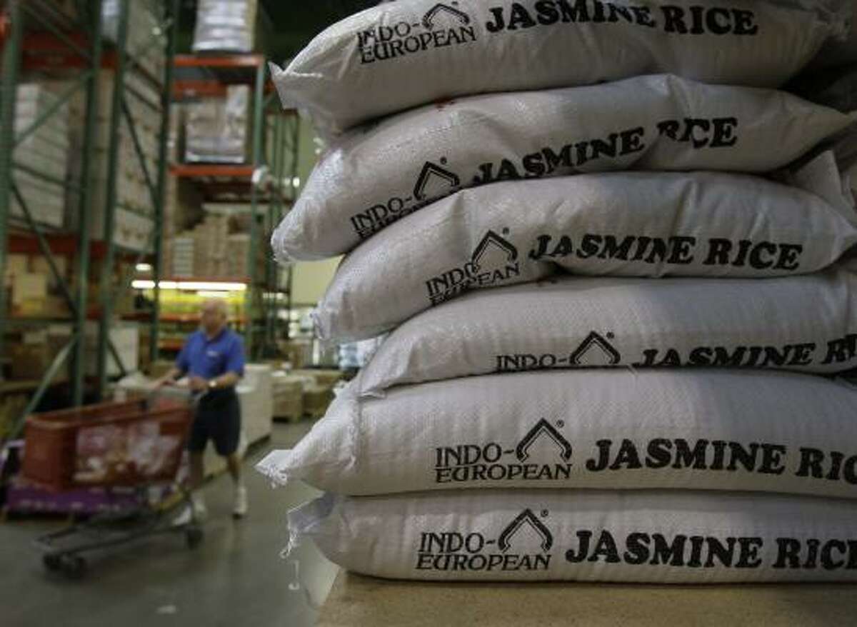 Bags of rice are stacked at Phoenicia Specialty Foods in west Houston on Thursday. Phoenicia had no limits on what customers could buy, but other stores were curtailing their rice sales.