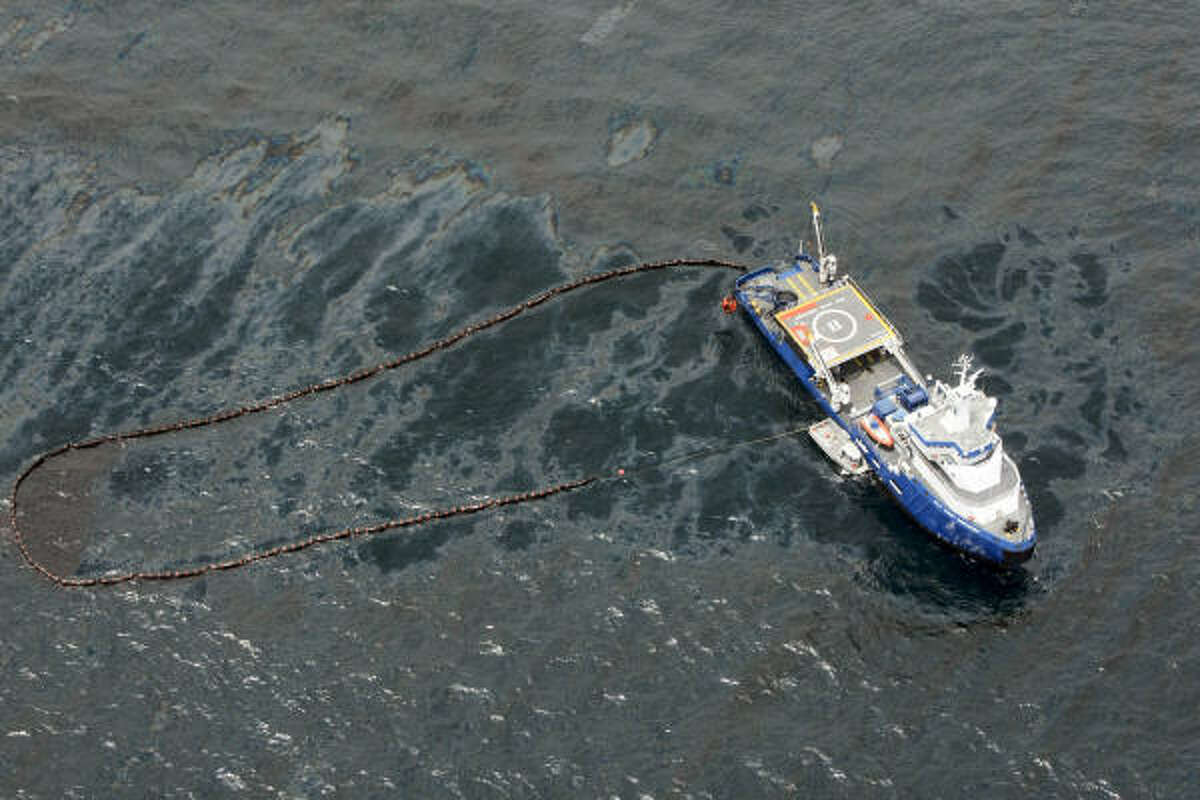 In an aerial photo taken in the Gulf of Mexico more than 50 miles southeast of Venice, La., a cleanup vessel deploys an oil boom to contain crude spilled from Tuesday's rig explosion.