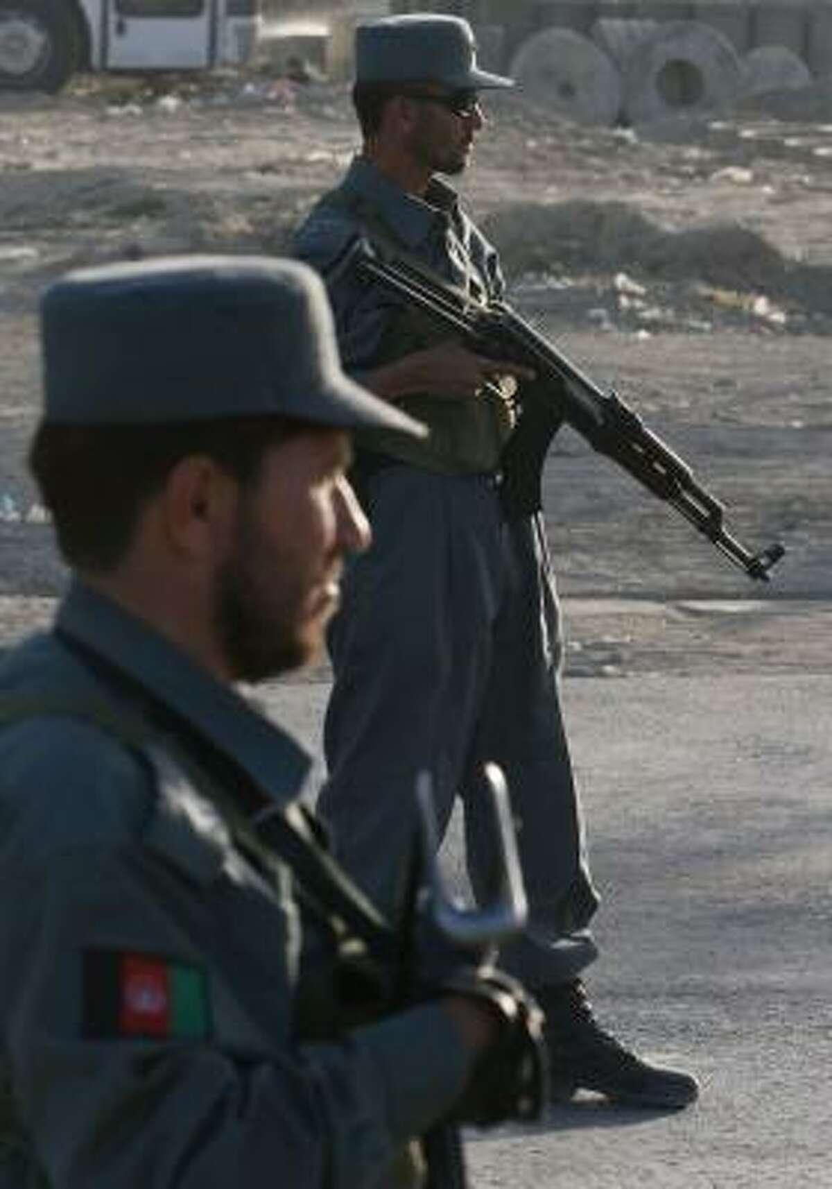 Afghan police officers stand guard at a Kabul checkpoint Monday after violence around Afghanistan killed dozens of people.