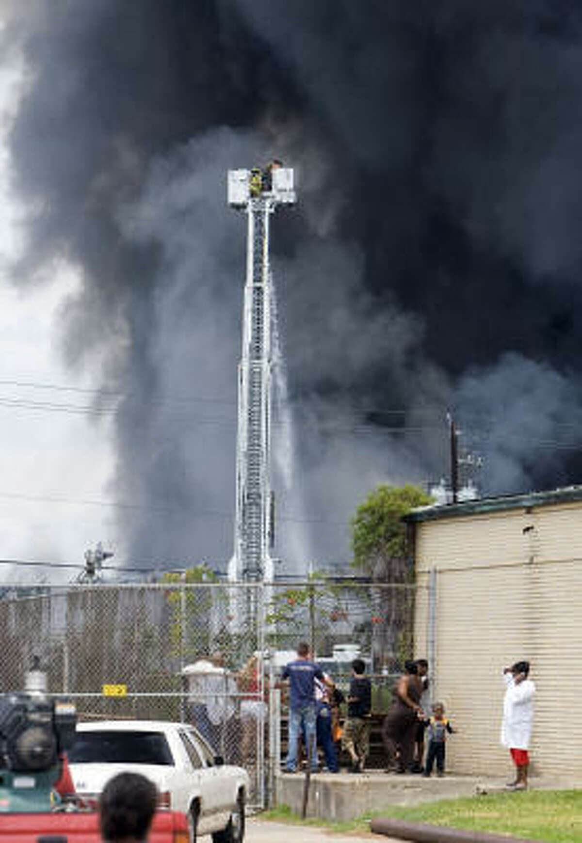 A crowd watches Houston firefighters battle the blaze at a building at Old Clinton Road and Shotwell on Saturday.