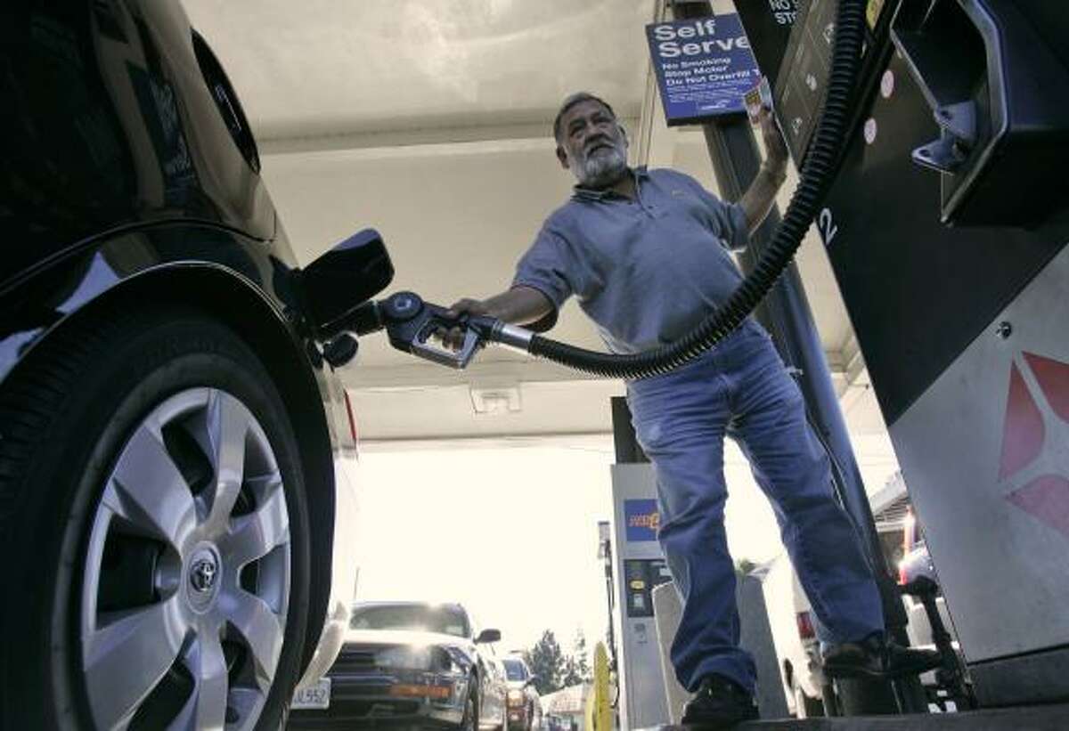 Santiago Santos fuels his car at a San Jose, Calif., station in November. The price of gasoline failed to keep up with the rise in crude oil.