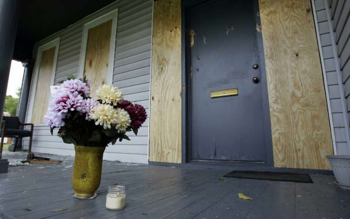 Flowers and a candle sit on the porch of a law firm Friday, a day after John Ashley killed two people there.