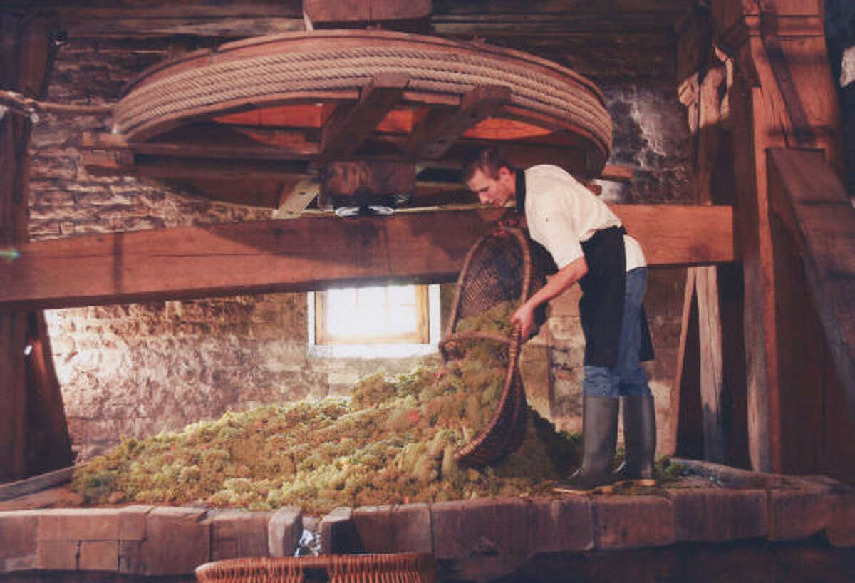 Some Clos des Mouches grapes are loaded into the Joseph Drouhin winery's antique press for a special pressing after the 2005 harvest.