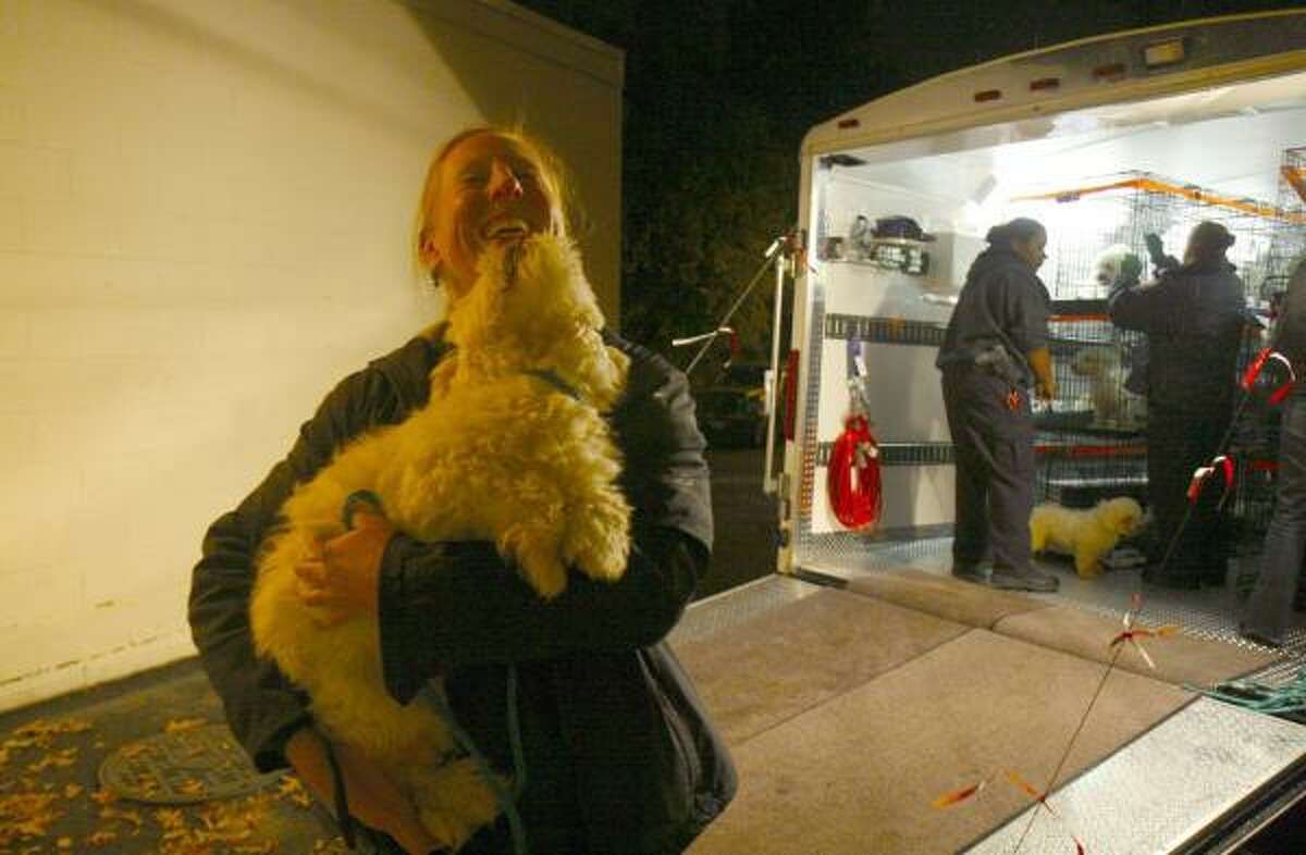 Suzanne D'Alonzo greets one of the rescued dogs at the Fairfax County, Va., animal shelter.
