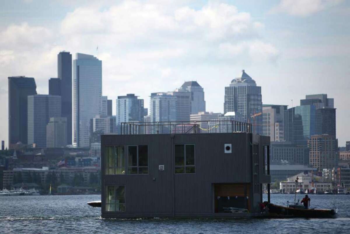 A floating home crosses Seattle's Lake Union, destined for Wards Cove, a new floating home community in Seattle's Eastlake neighborhood on Friday, July 22, 2011. The floating home slips at Wards Cove are billed as the last new floating home spots available on Lake Union.