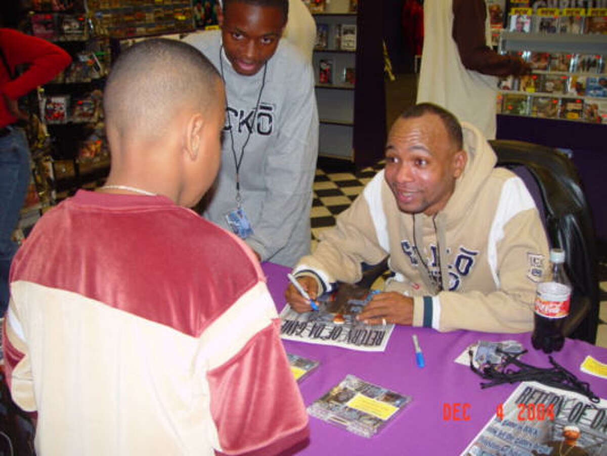 O.G. Style signs an autograph for a young fan in December 2004.