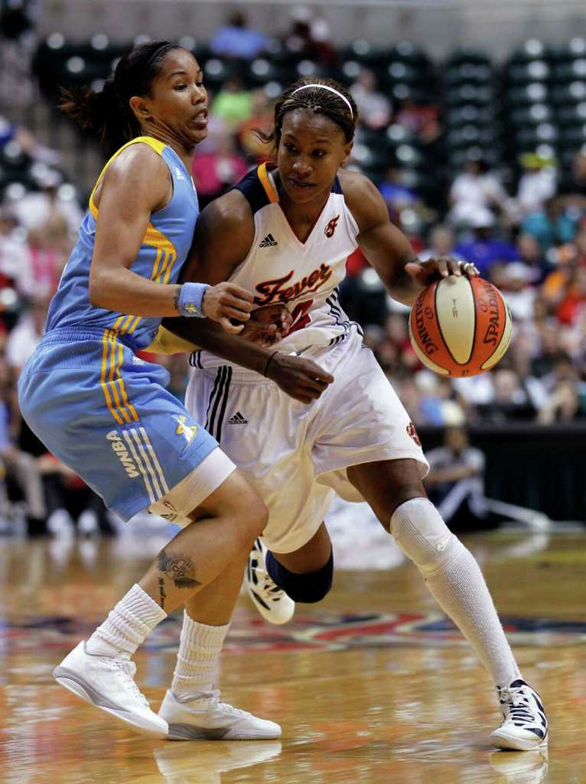 Indiana Fever forward Tamika Catchings, right, works the ball as Chicago Sky's Tamera Young defends during the second half of a WNBA basketball game in Indianapolis, Thursday, July 21, 2011. The Fever defeated the Sky 77-63. (AP Photo/Michael Conroy)