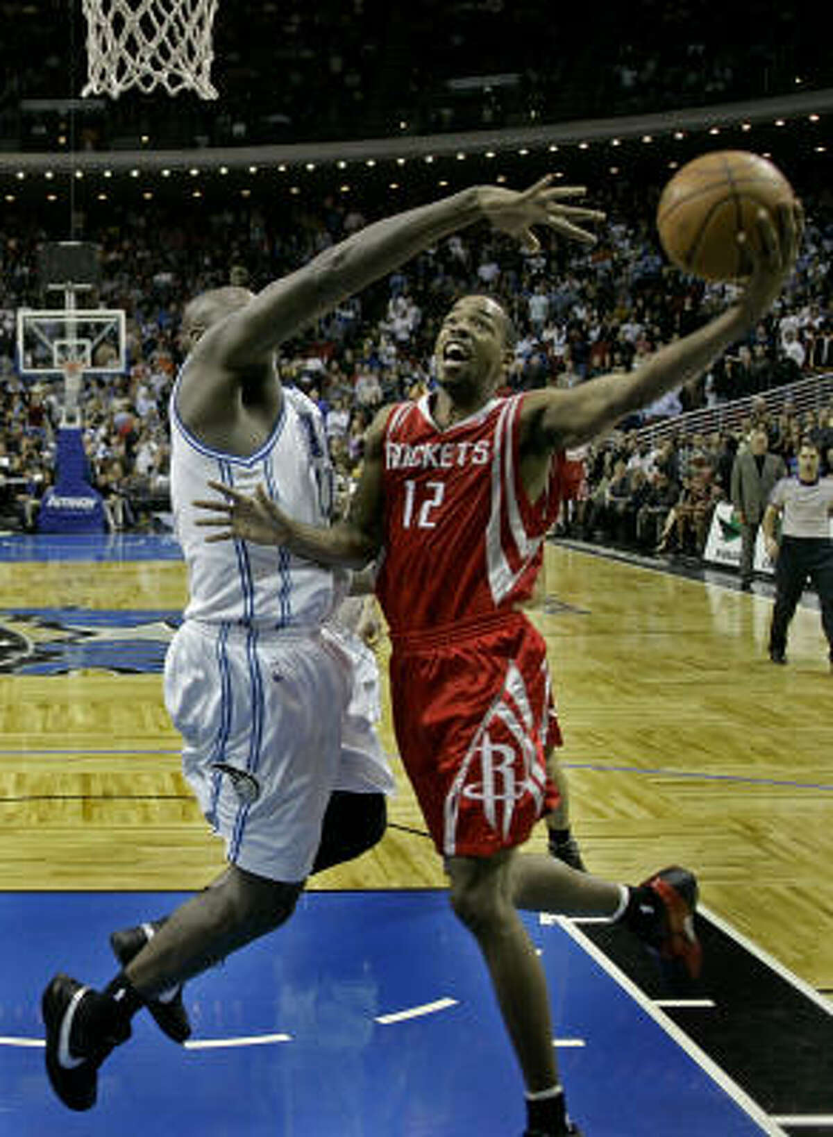 Rockets guard Rafer Alston (12) makes a shot over Magic center Adonal Foyle with 4.3 seconds left to help the Rockets escape Orlando with a 96-94 win Friday.