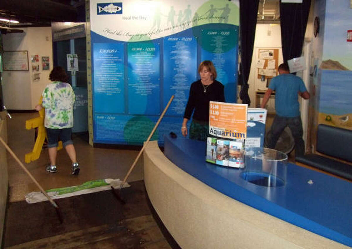 This image provided by Heal the Bay shows employees of the Santa Monica Pier Aquarium cleaning up after an octopus tank spill Tuesday in Santa Monica, Calif.