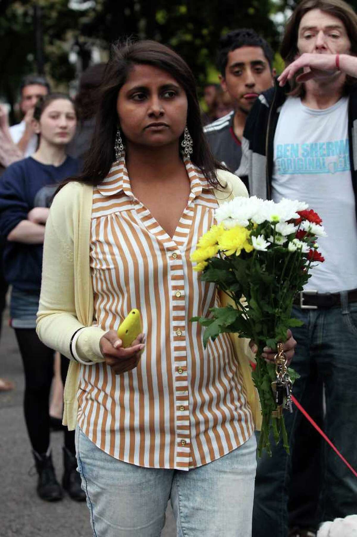 A mourner carries flowers outside Amy Winehouse's North London Home on July 23, 2011 in London, England. Singer Winehouse, 27, was found dead today.