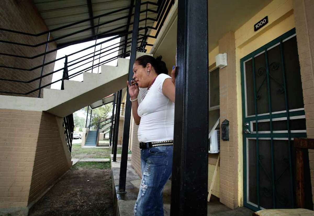 Norma Garcia, who lives in the Wheatley Courts, smokes in front of her apartment.