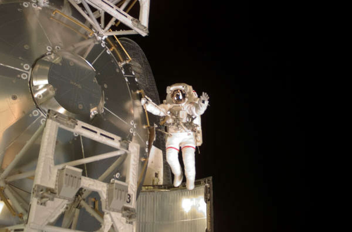 Astronaut Rex Walheim holds onto a handrail on the Columbus laboratory and spreads his arms Friday. The shuttle could be ready to land by Wednesday.