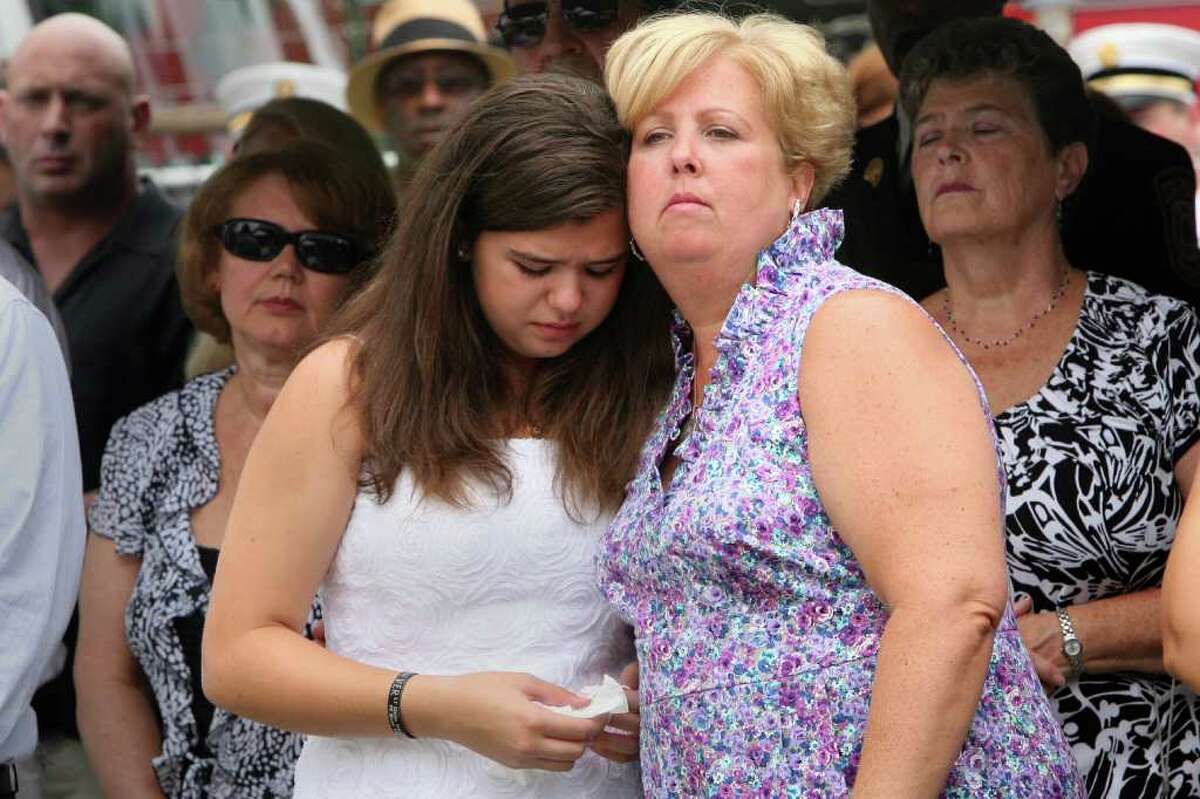 Widow Laurie Baik and her daughter, Margaret, attend a Bridgeport Fire Department Memorial Dedication ceremony honoring firefighter Michel Baik and Lt. Steven Velasquez on Sunday, July 24, 2011. The firefighters were killed in the line of duty last year. The ceremony took place at the Engine 7/ Ladder 11 firehouse on Ocean Terrace.