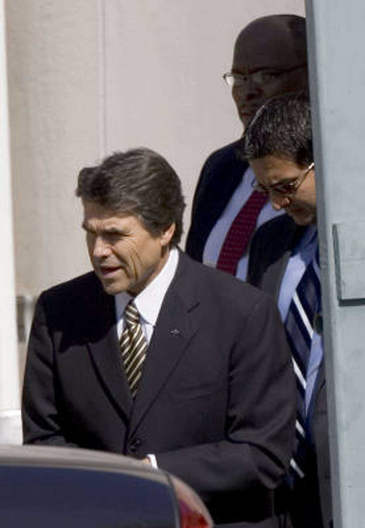 Gov. Rick Perry leaves a meeting with African-American ministers at a Houston hotel Thursday.