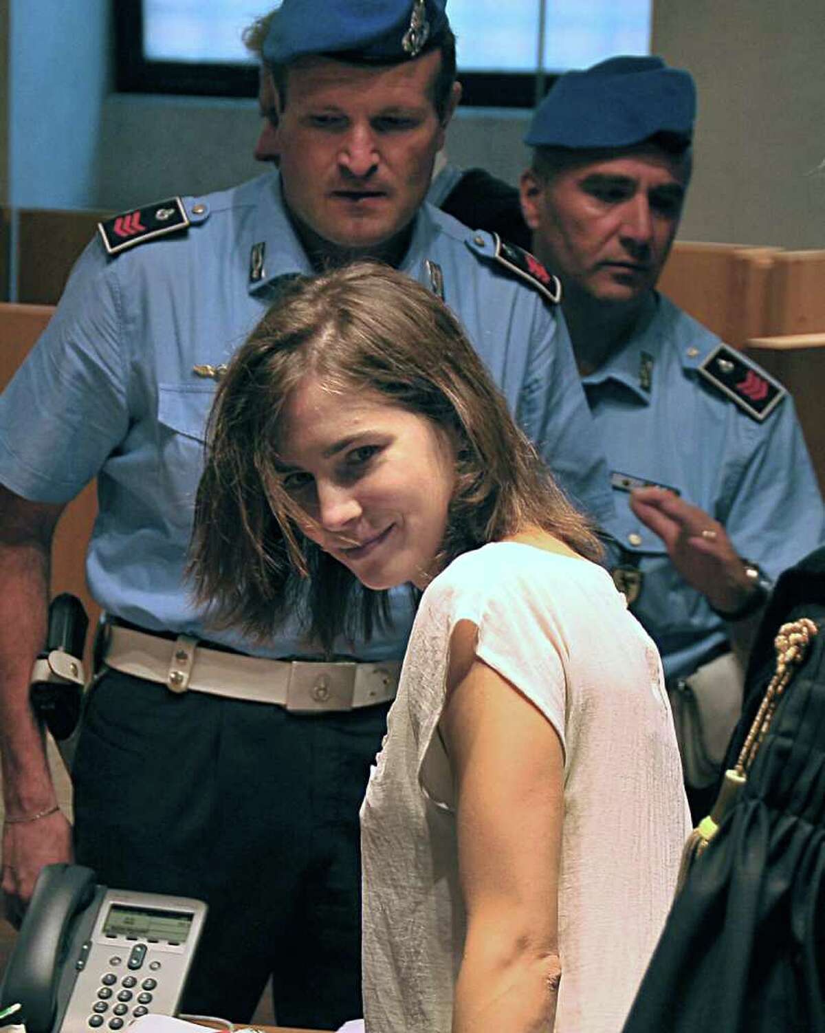 American student Amanda Knox looks at photographers during a hearing in Perugia, Italy on Monday. Independent experts presented the conclusions of their review of the DNA evidence collected against  Knox and her co-defendant Raffaele Sollecito. DNA evidence played a crucial role in securing the convictions of Amanda and Raffaele Sollecito in the 2007 murder of Meredith Kercher, who was stabbed to death in the apartment she shared with the Seattle exchange student. (AP Photo/Stefano Medici)
