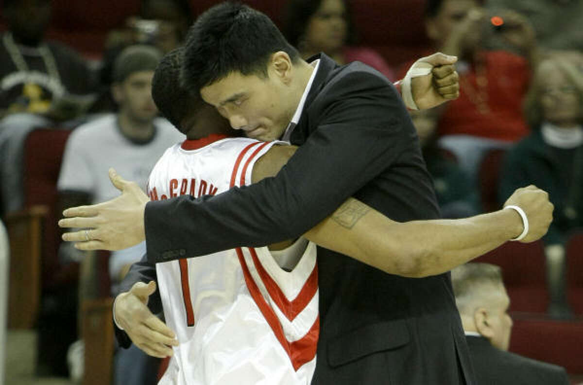 Sidelined Rockets center Yao Ming, right, embraces his teammate Tracy McGrady.
