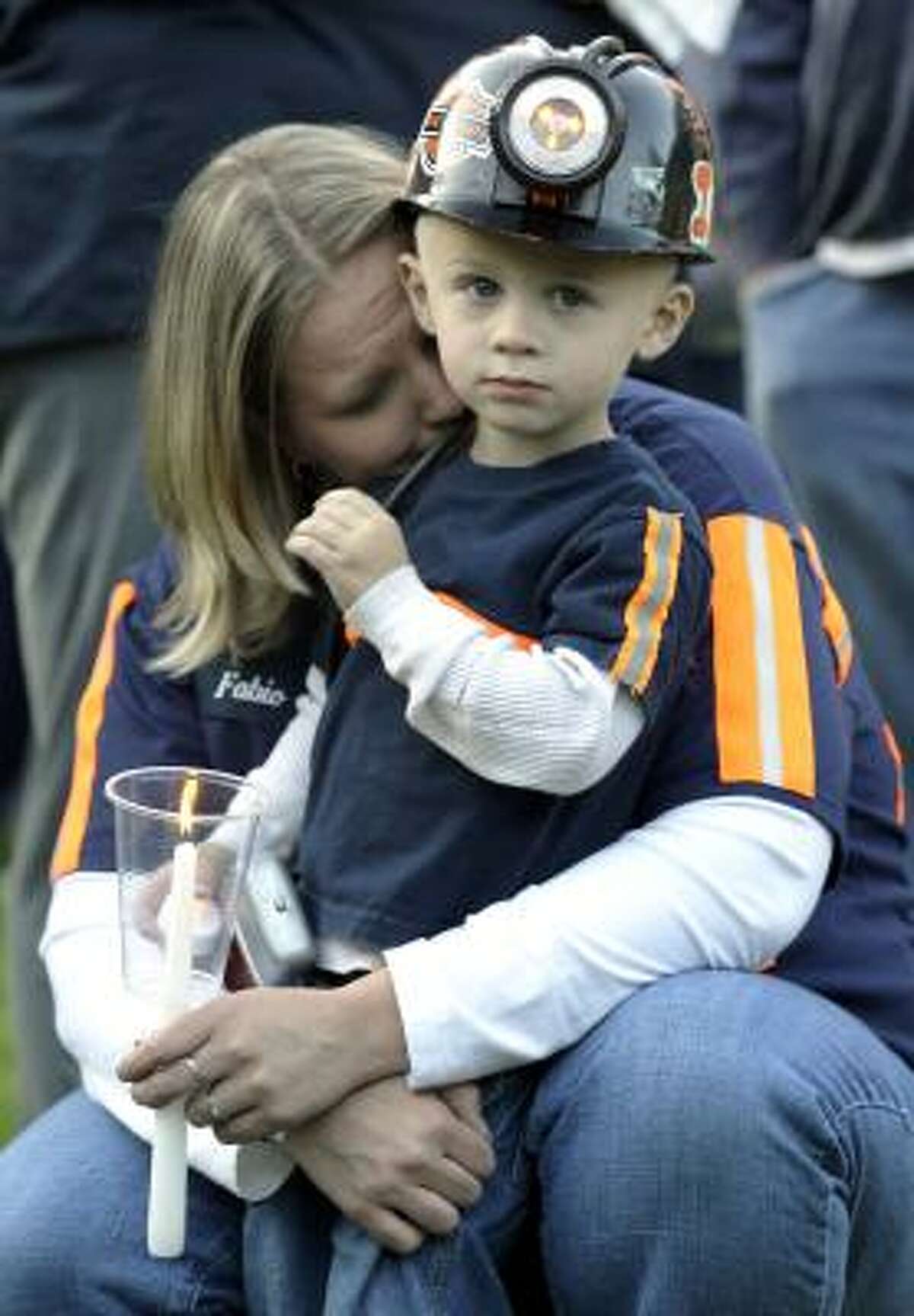 A woman and her son embrace at a memorial for 29 victims of the Upper Big Branch mine disaster in Montcoal, W.Va.
