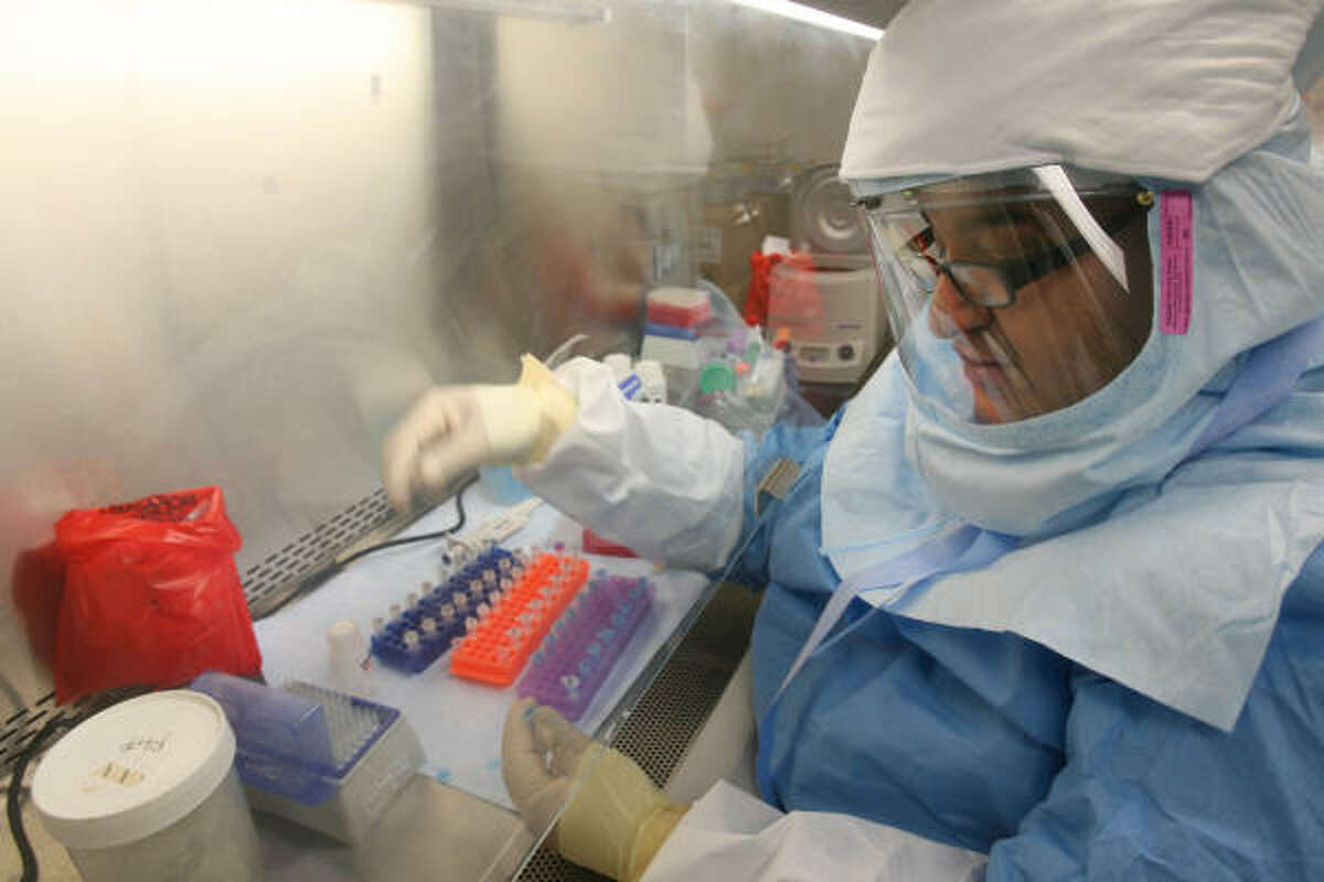 Scientist Ricardo Quijano works on virus samples at the Houston health department on Friday.