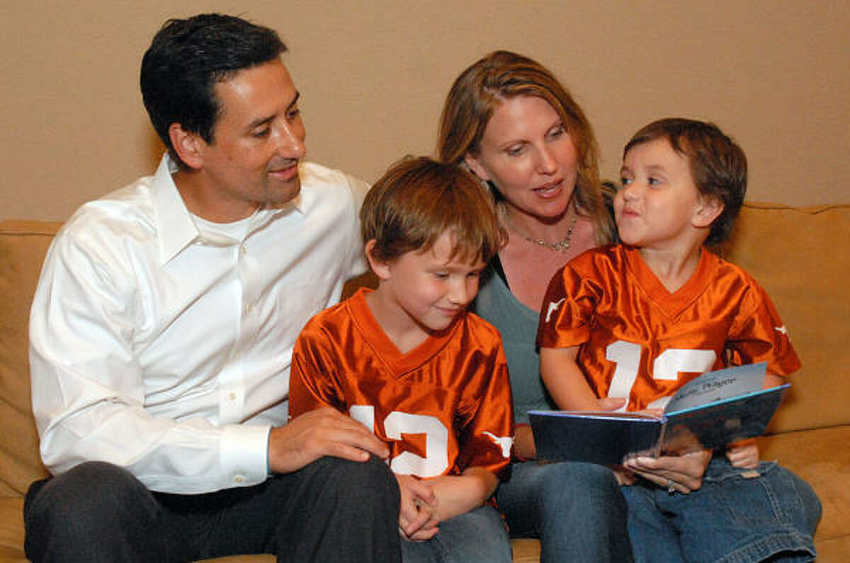 Heinrich Meermann listens as his wife, Heather, reads a book to their sons, Dresden and Grant. Grant has Duchenne Muscular Dystrophy, a fatal degenerative disease. College football coaches across the nation are participating in Coach 2 Cure, an event that raises awareness and money for research Duchenne. Photo by David Hopper