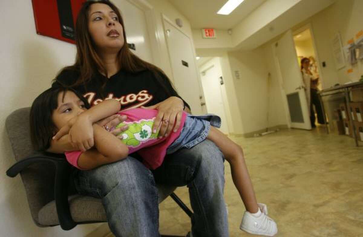 Raquel Rangel waits with her daughter Aaliyah Rodriguez at Denver Harbor Clinic on Friday as doctors are examining two of her children who have high fevers.