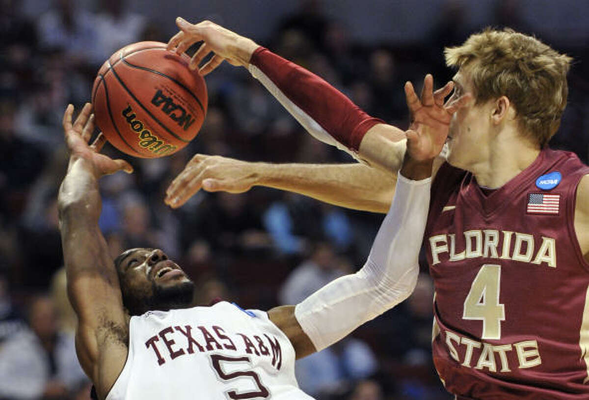 Texas A&M's Dash Harris falls backward after Florida State's Deividas Dulkys blocked his shot.