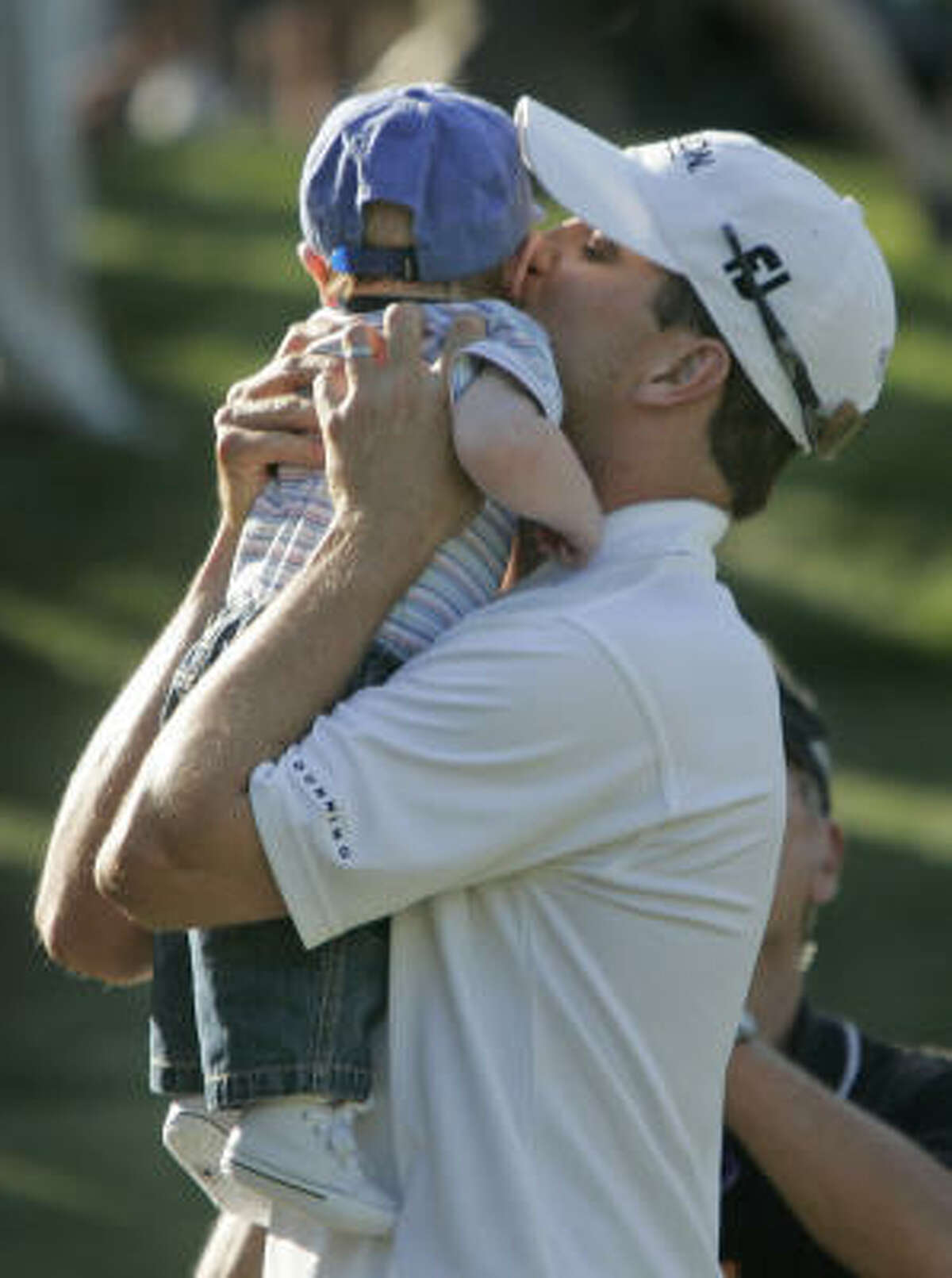 Zach Johnson celebrates with his four-month-old son, Will, after defeating Ryuji Imada in a one-hole playoff to win the AT&T Classic.