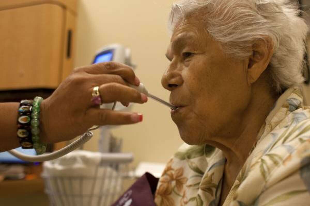 Isabel Nuñez, 86, gets her temperature taken at the UT Center for Healthy Aging. In her recent visit there, an examination by a geriatric primary care physician revealed that Nuñez might be showing early signs of dementia.
