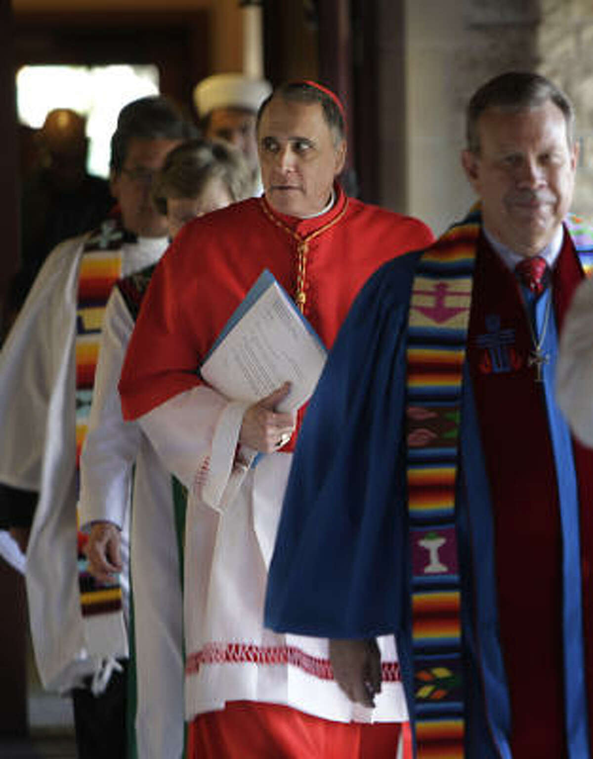 Cardinal Daniel DiNardo, carrying papers, was among the local religious leaders attending an interfaith prayer service to renew a call for immigration reform.