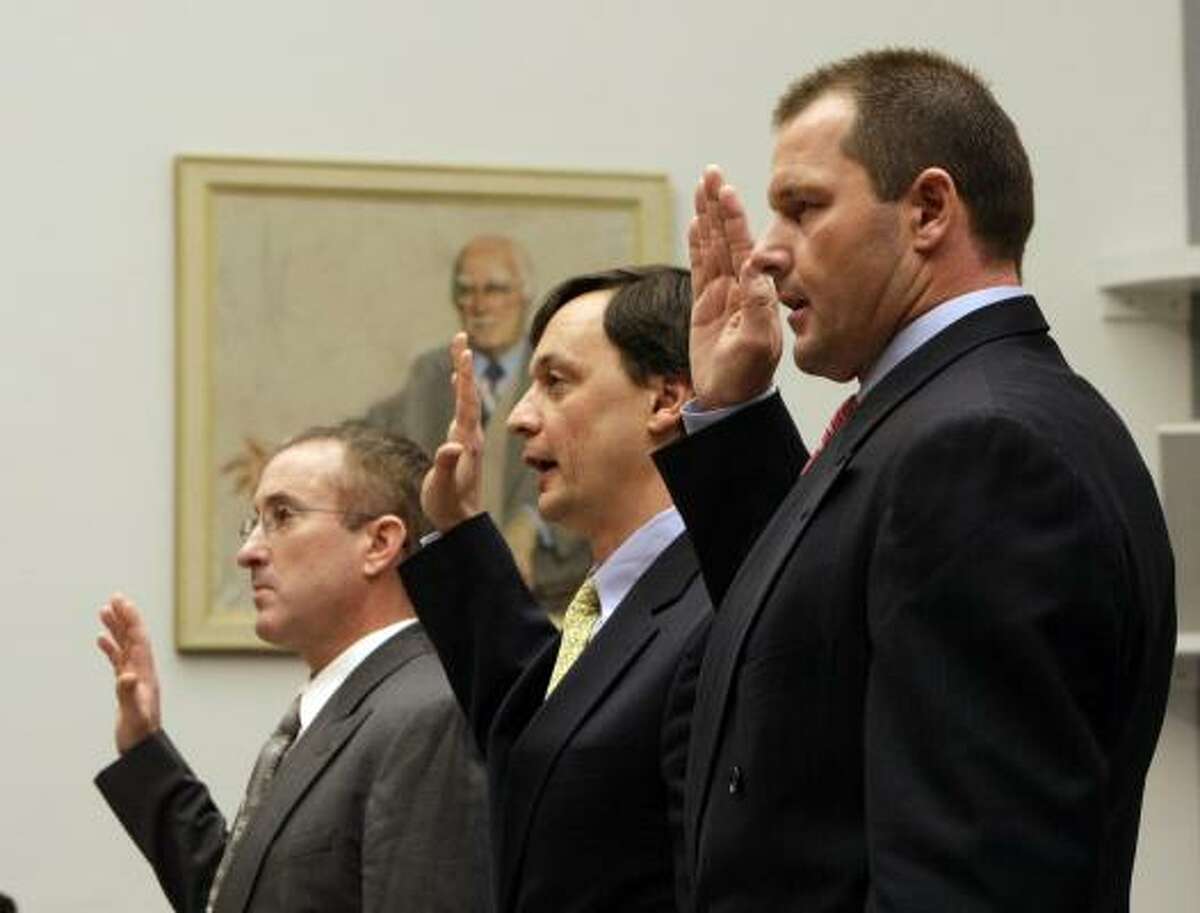 Former Astros pitcher Roger Clemens, right, lawyer Charles Scheeler center, and Clemens' former personal trainer Brian McNamee, are sworn in.