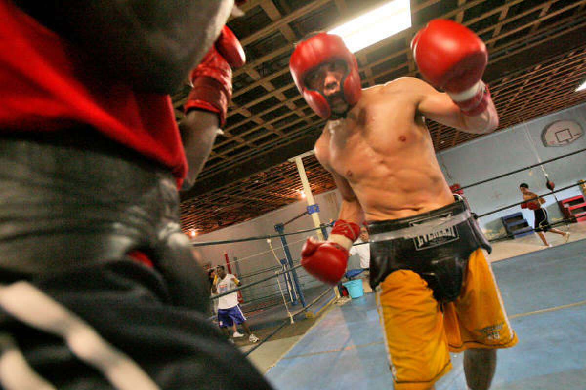 Raul Marquez (yellow trunks) spars with Cliff Newton during a recent workout in Baytown.