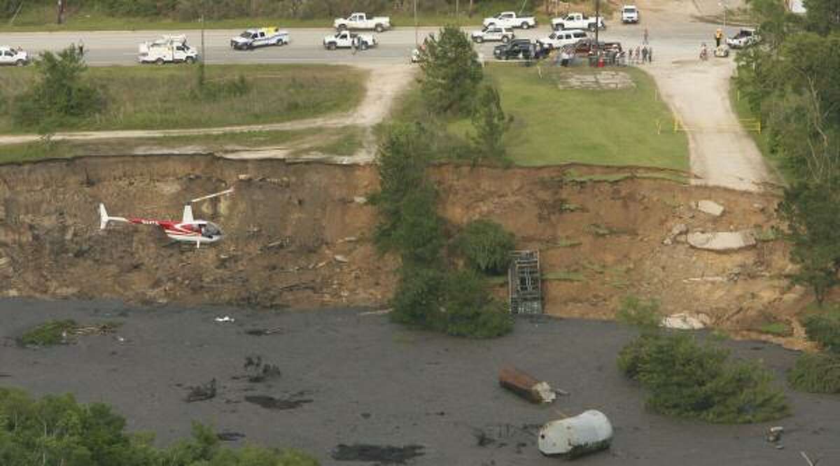A helicopter hovers above the Daisetta sinkhole in March when the crater was growing at 20 feet an hour. Thousands of dollars in studies later, the cause of the sinkhole remains unclear.
