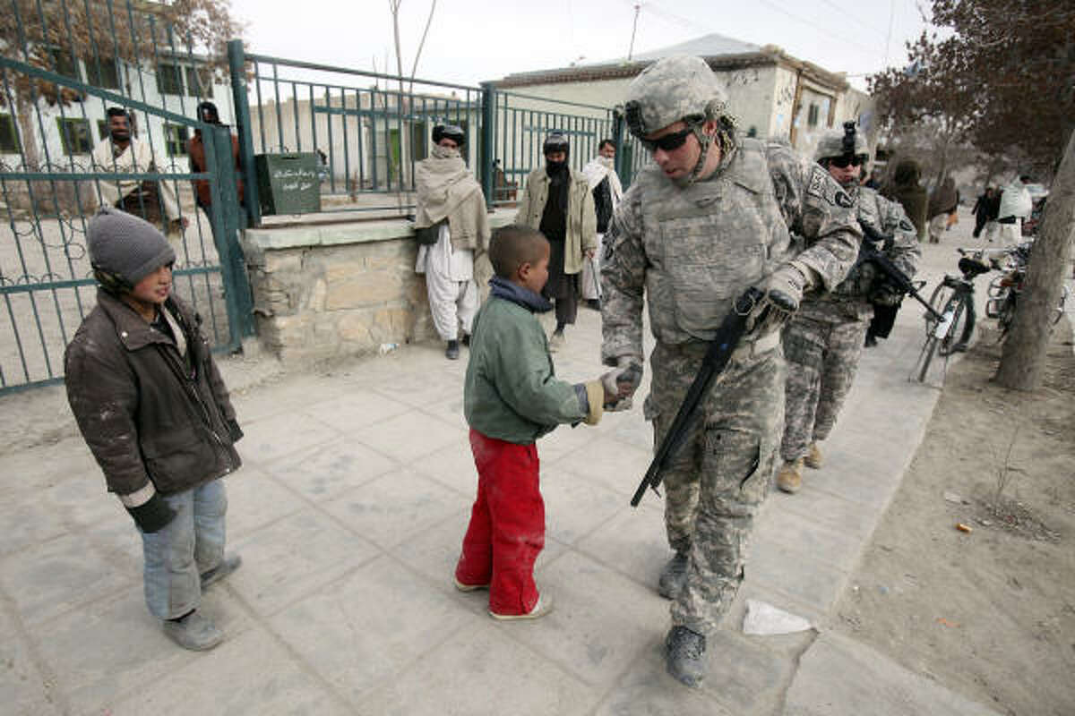 Texas Army National Guard Sgt. Davin Marceau, 28, of Austin, says goodbye to Afghan boys as his tour ends Saturday.