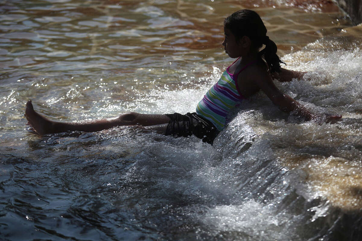 Kimberly Uranga, 9, rests in the water as she swims in the San Pedro Springs Park pool in San Antonio on July 26, 2011.