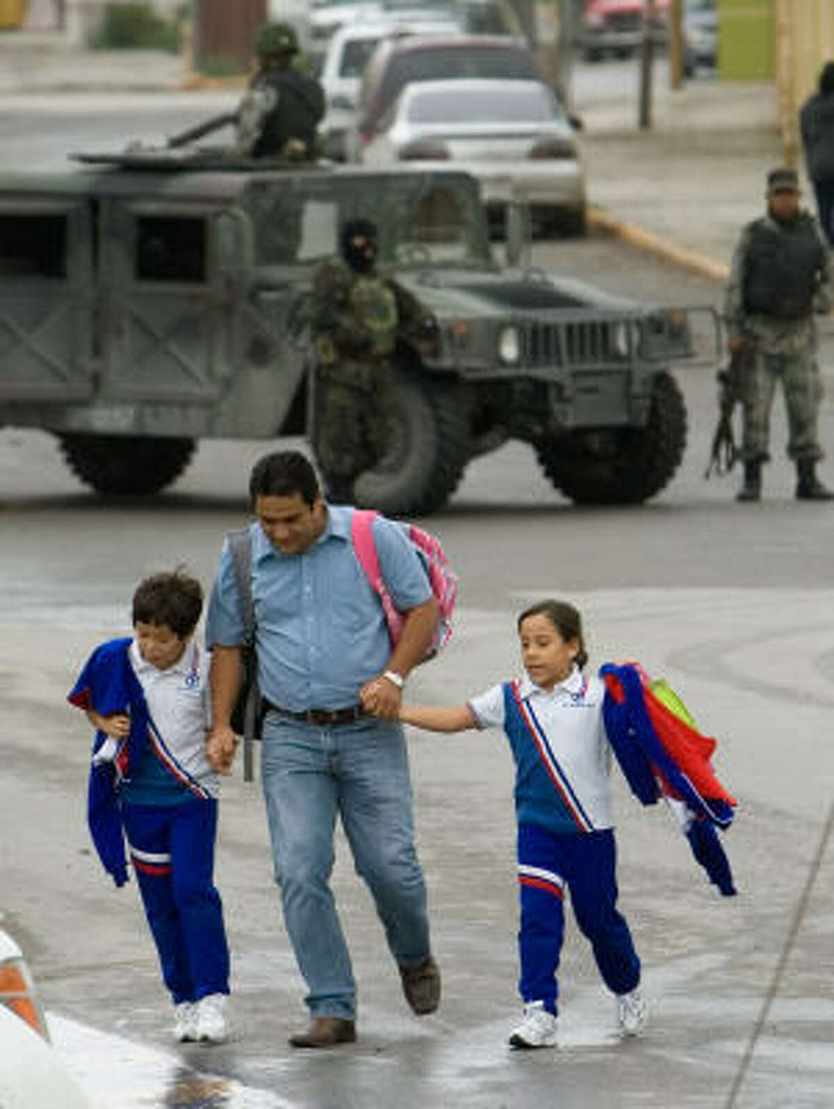 A man and his children scramble for safety near the Carrillo Puerto Primary School.