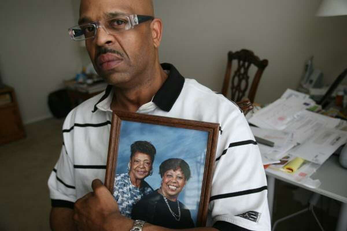 Theron Owens holds holds a photo of his grandmother, Alberta Walker, and his mother, Joyce Owens, found slain Friday.
