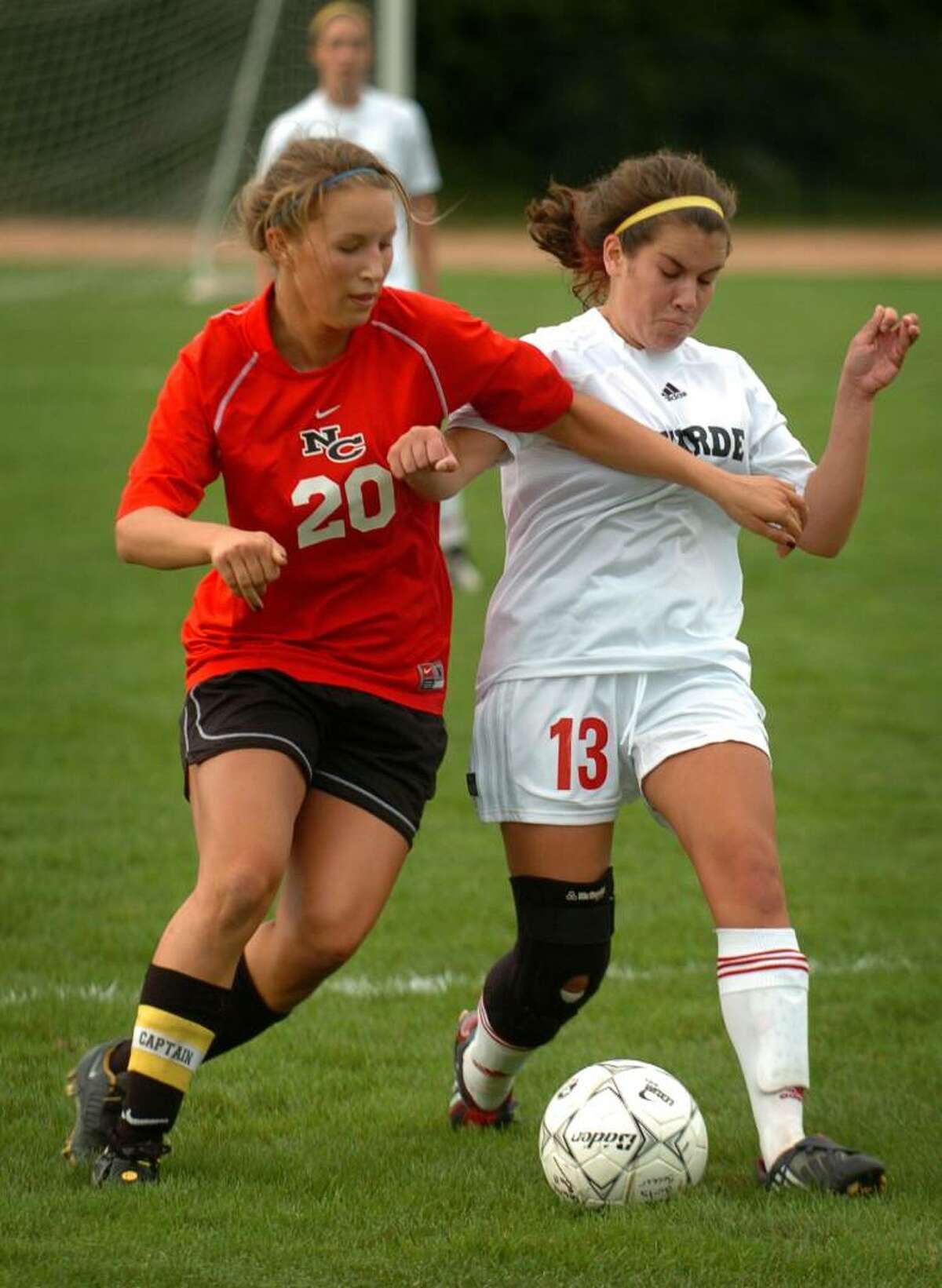 New Canaan's Clare Ashforth, left, battles for the ball with Fairfield Warde's Hannah McGrath during their FCIAC matchup at Warde High School in Fairfield, Conn. on Wednesday, September 30, 2009.