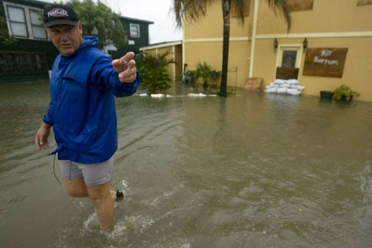 Gilchrist resident Ricky Tribble walks Tuesday from his Bolivar Peninsula home, flooded with a foot of water by Edouard.